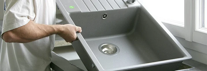 Person baut Spüle ein